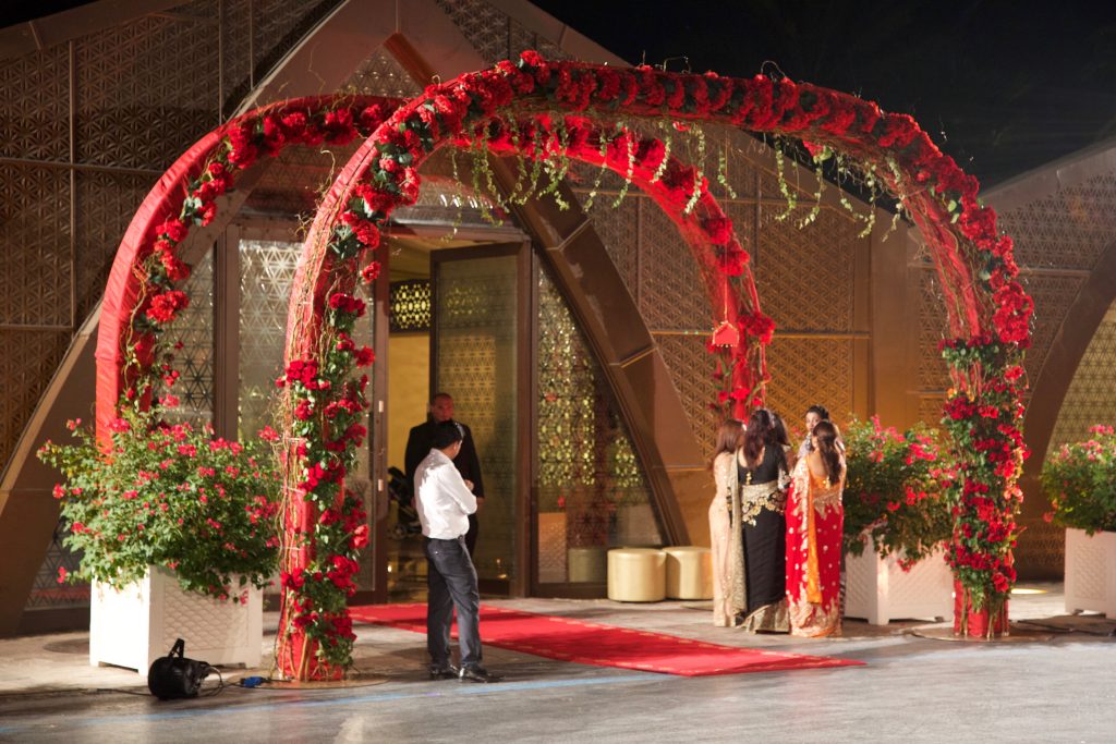 A floral wedding arch decorated with lush red flowers, beautifully situated in Dubai