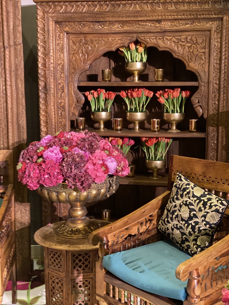 A room with two chairs and a wooden cabinet, enhanced by colorful Eid decor.