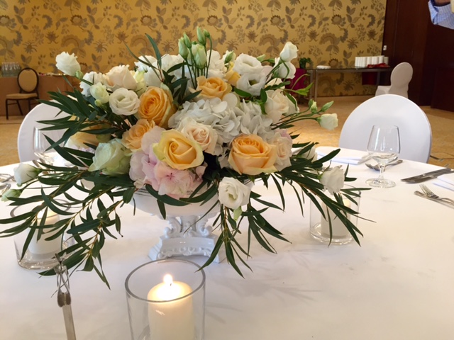 A vase filled with white and yellow flowers sits on a table, adding a touch of elegance to the setting.