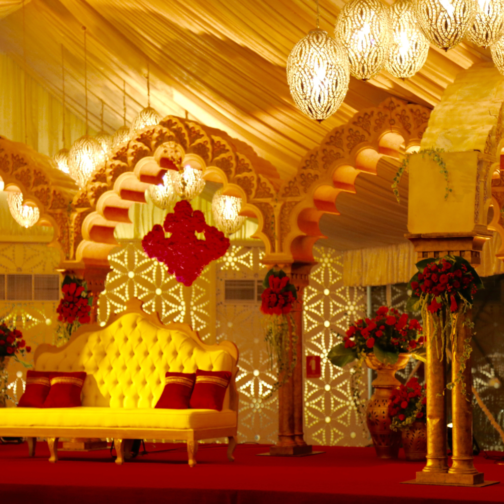 A vintage-inspired wedding stage adorned with vibrant red and yellow flowers and decor, creating a romantic atmosphere.